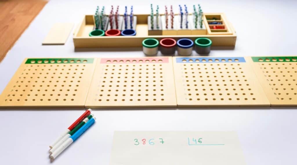 A picture of the Montessori racks and tubes material on a table, ready for an elementary student to engage with.