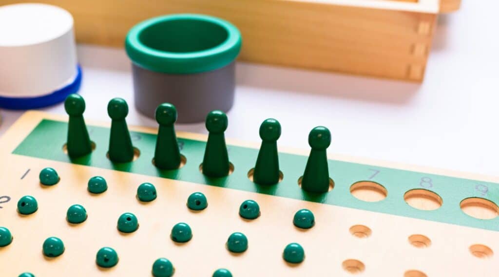 The Montessori long division material, racks and tubes, ready for a single digit divisor quesiton.