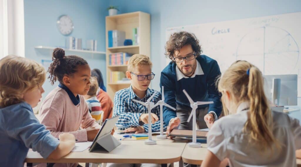 A teacher with a small group of elementary students working on a project together. The Montessori prepared environment gives them a chance to work with their hands and peers.