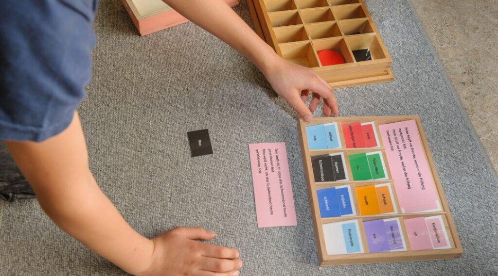 A grade 1 student is practicing with Montessori parts of speech tasks.