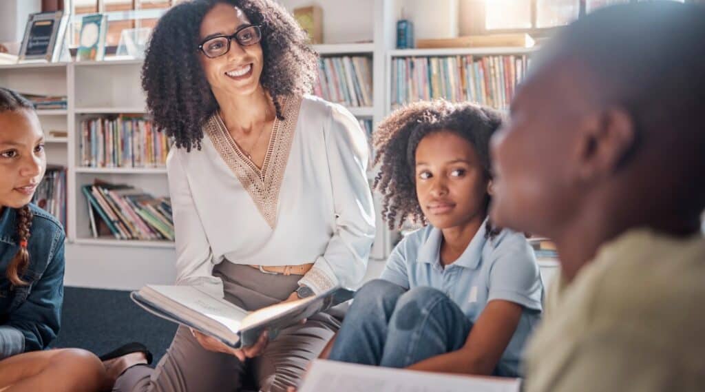 A teacher and students enjoying a discussion as they read together.