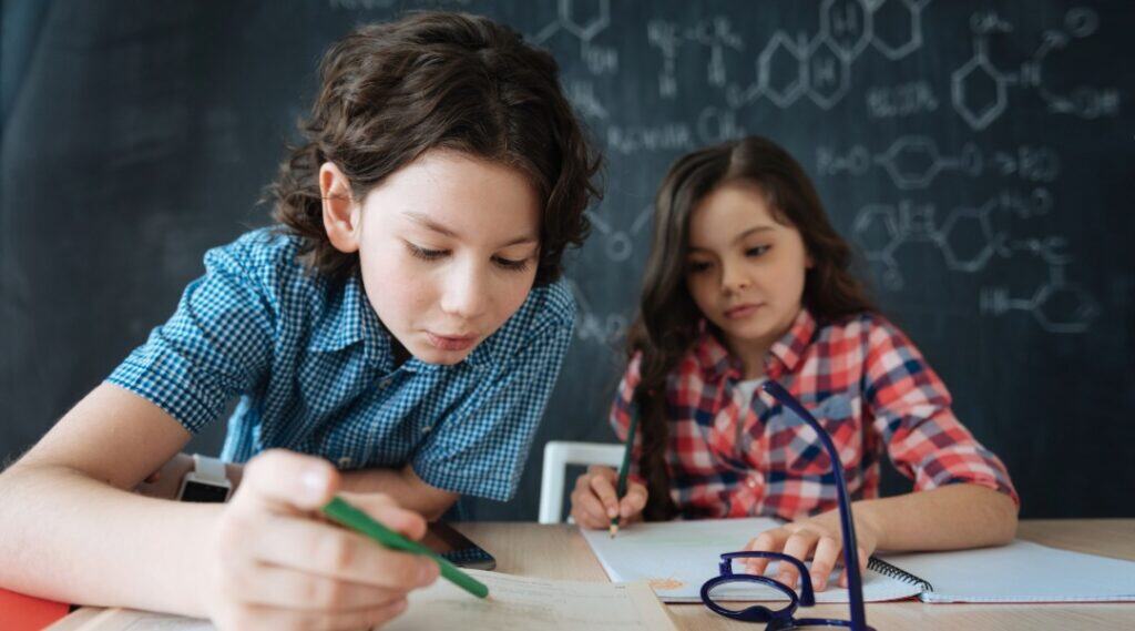 Two elementary students exploring a teachable moments example that has them searching the dictionary together.