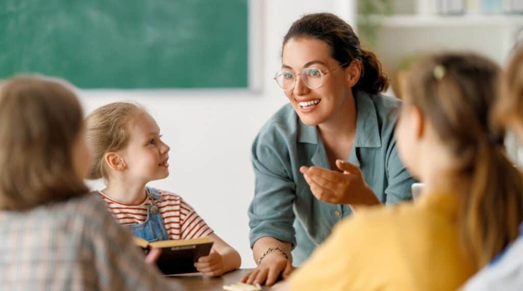 A picture of a teacher and a small group of students about to explore a few teachable moments examples in their novel study group.
