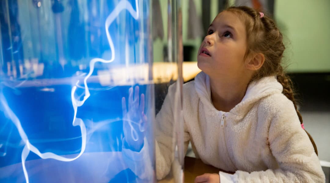 A young girl mesmerized by what she's seeing at a museum. This is a great way to beat the summer brain drain.