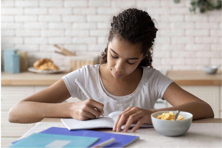 An 11 year old girl sits at the kitchen table with a pencil in her hand. She is writing a book review for something she just finished reading. This is yet another of the awesome summer reading activities elementary kids will love!