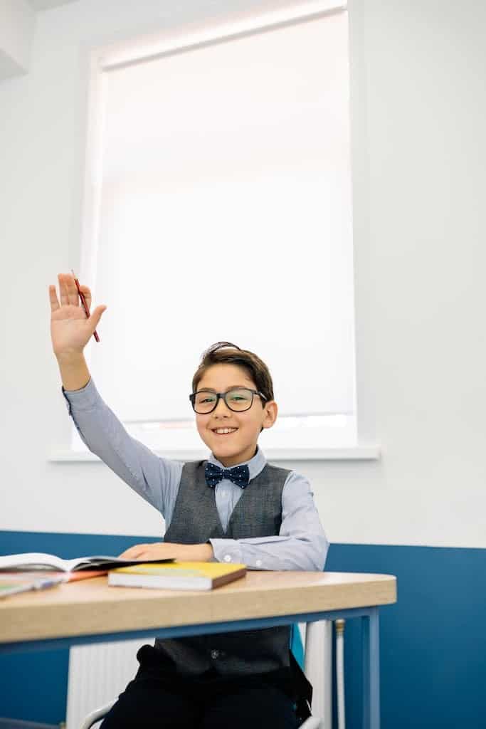 Elementary Student raising his Hand because he has the answer to the rebus puzzle