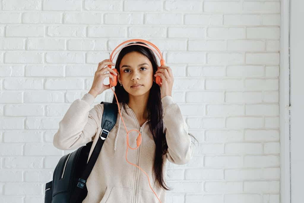 Girl with Black Backpack Wearing Orange Headphones