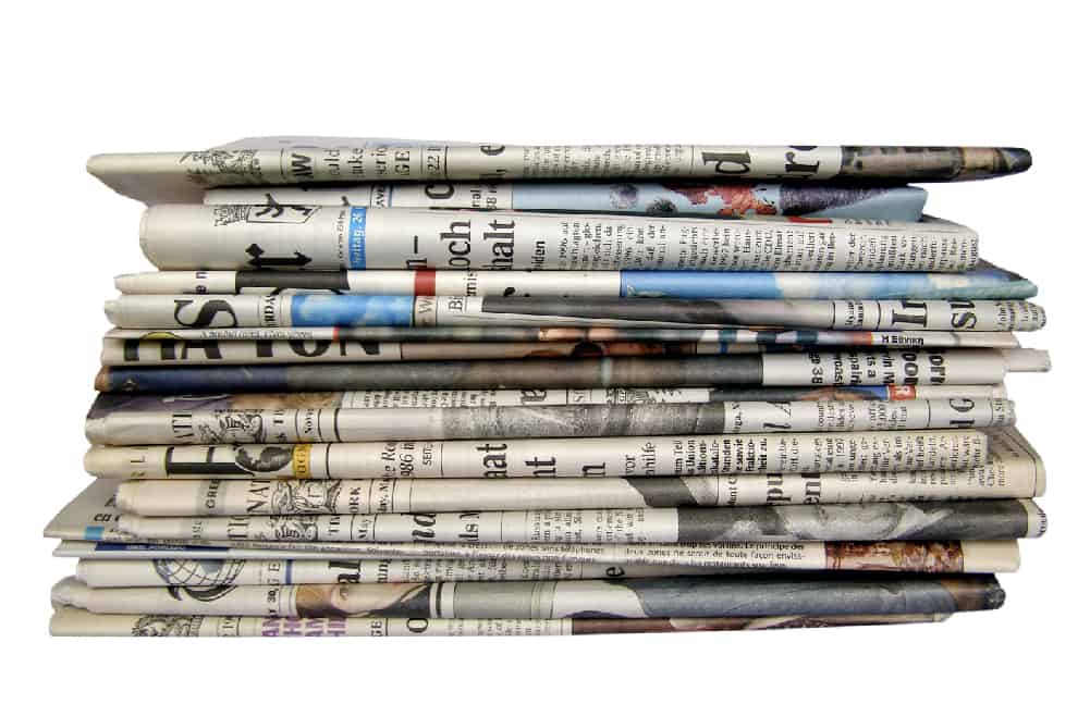 A stack of newspapers. Children can search through the newspaper for unfamiliar words to add to their library scavenger hunt checklist.