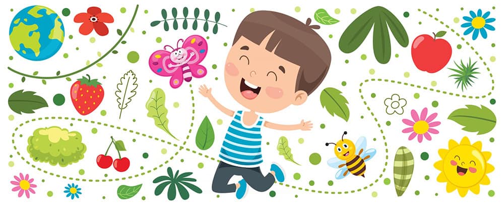 An image of an elementary-aged boy smiling and very happy surrounded by nature. 
