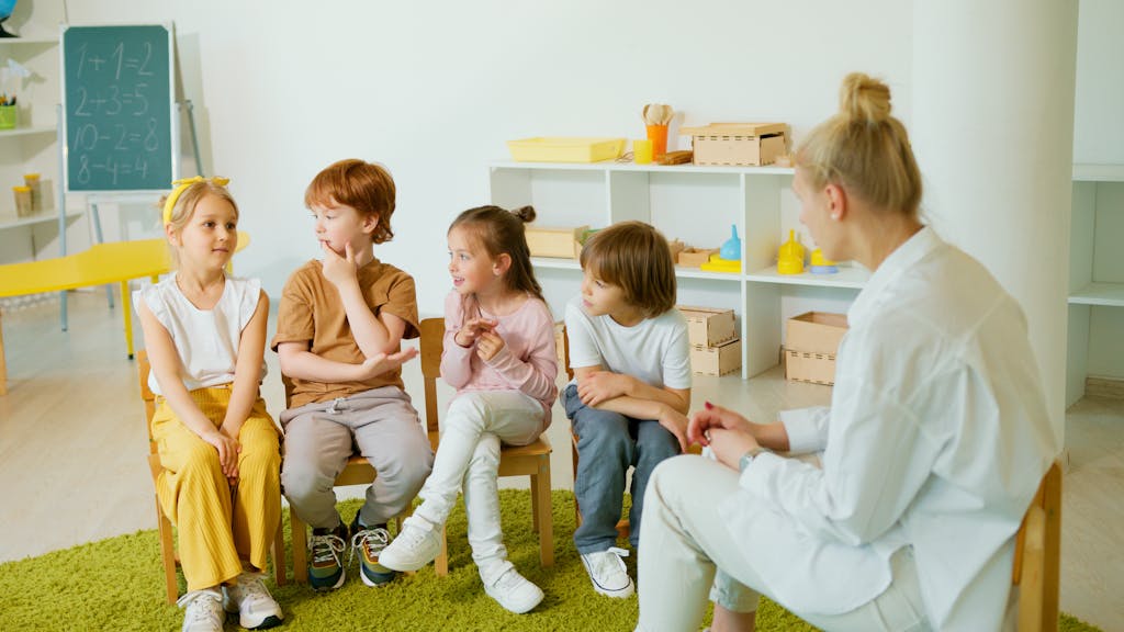 Kids Sitting on Chairs playing a parts of speech game with their teacher