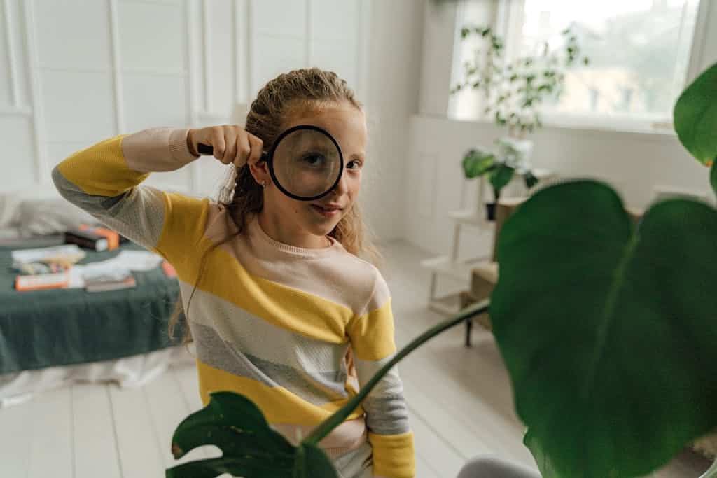 A young girl Looking Through a Magnifying Glass as she completed a parts of speech activity in class.