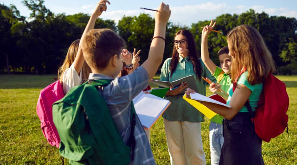 A group of upper elementary students getting excited about their outdoor alphabet scavenger hunt.