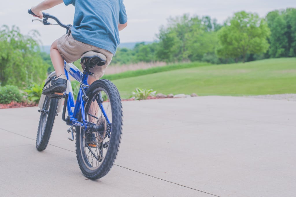 A young boy enjoying a ride on a blue bicycle in a lush outdoor setting. This is always one of my go-to summer math activities
