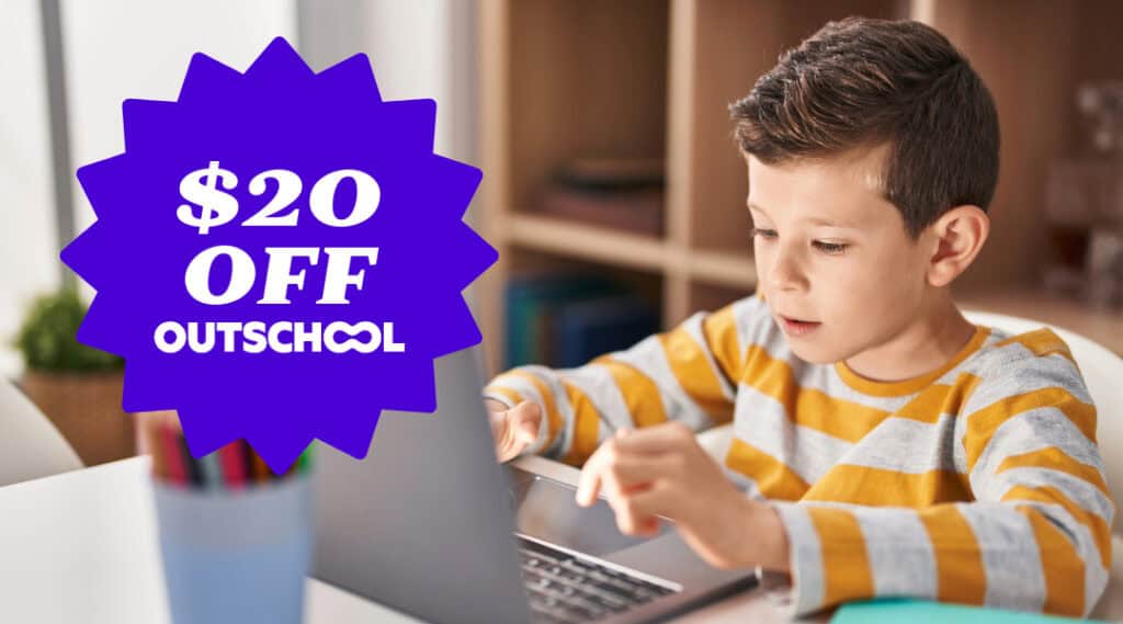 A picture of an elementary-aged boy sitting at a lap top doing an Outschool class.