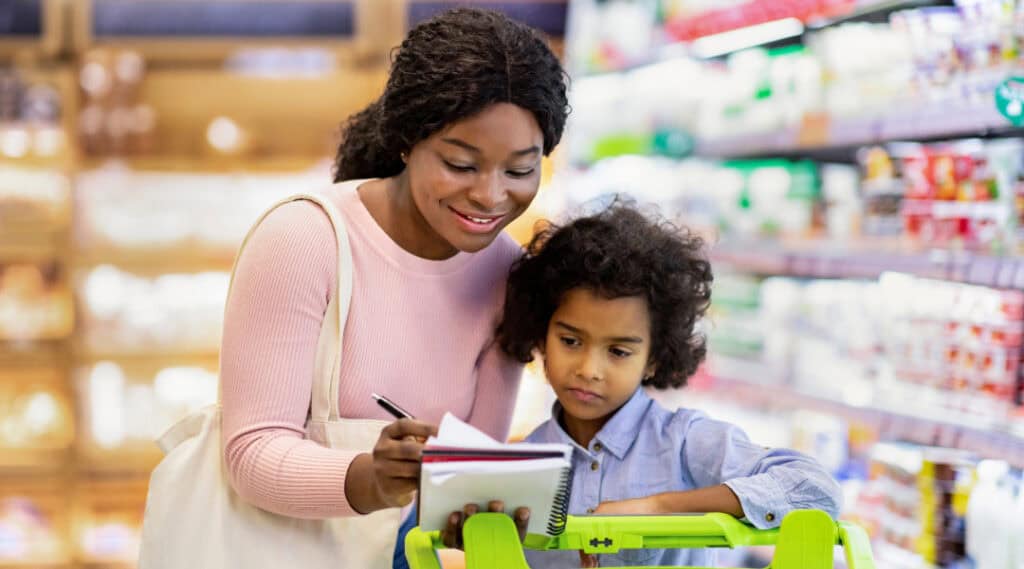 A mom and daughter at the supermarket together.