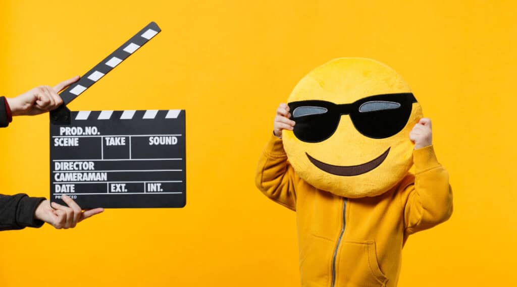 An emoji mascot with an action slapper.