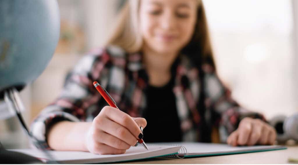 A picture of an upper elementary girl writing proudly with her new mechanical pencil.