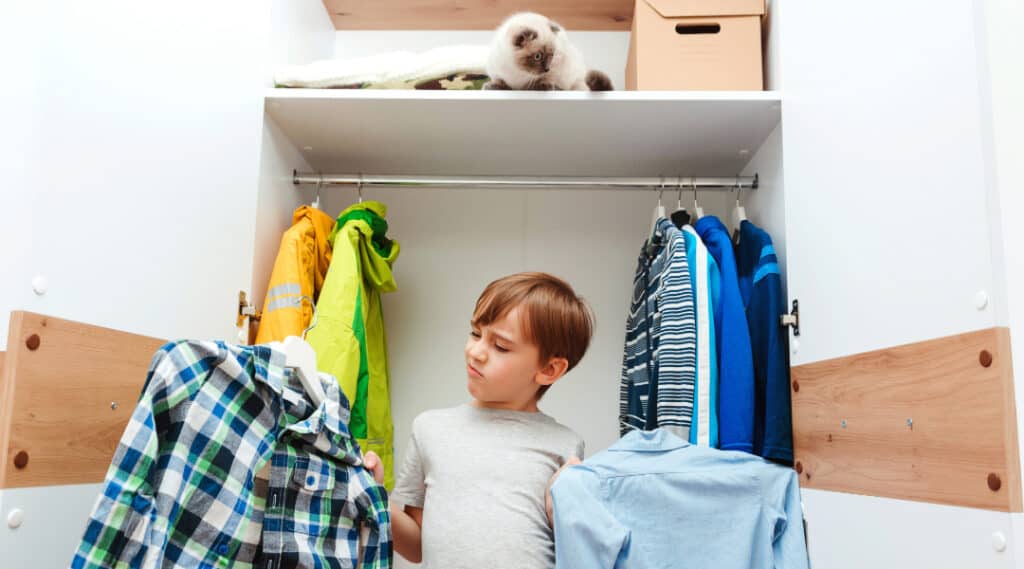 An image of a 9 year old boy choosing his outfit for school. Another popular one, this back to school tip for families encourages independance.