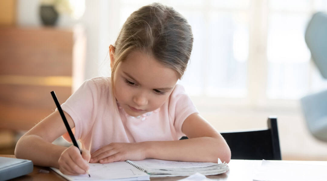A young girl writing in her notebook.