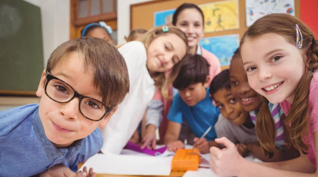 A picture of a small group of students with their teacher. Everyone is excited to be back at school!