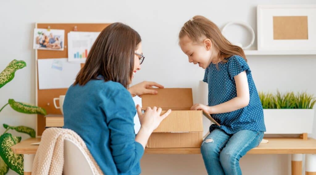 A mom and daughter are excited to open their educational subscription box.