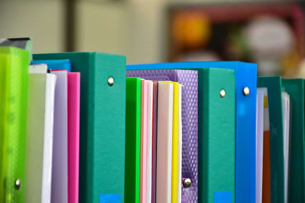 A picture of a shelf full of binders. Add binders to your list of back to school supplies for your upper elementary child.