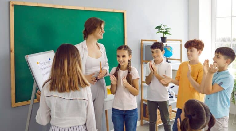 An image of a teacher and some students gathered together to play some parts of speech activities.