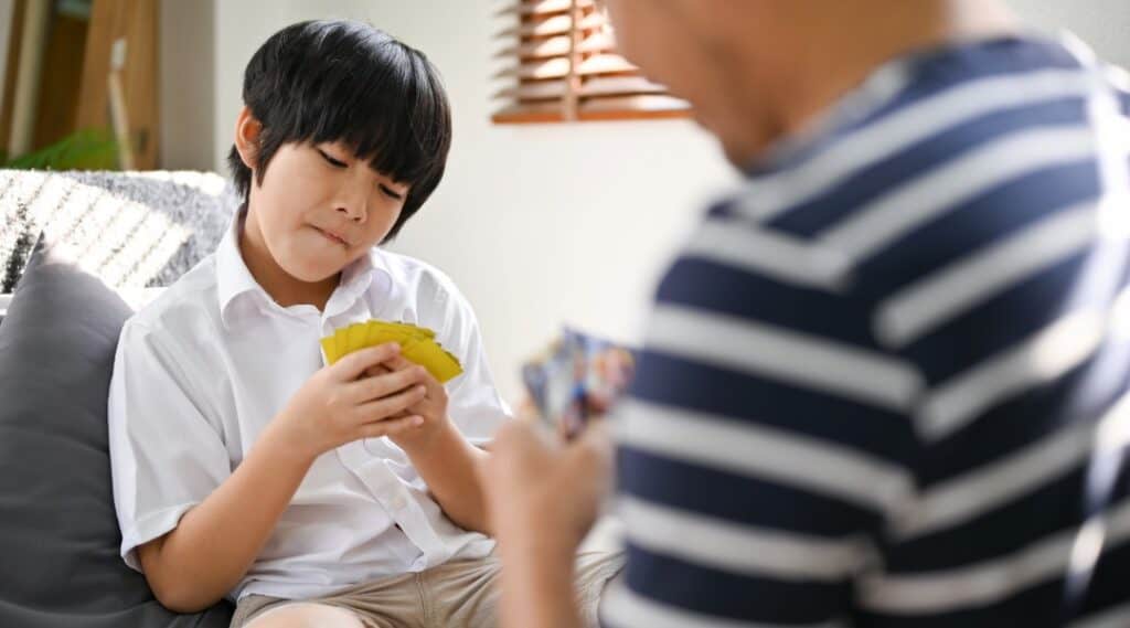 Two young boys are playing a math card game together