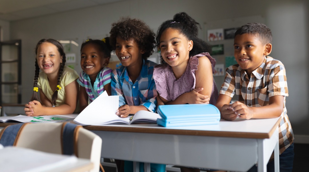 A group of happy kids in the classroom.