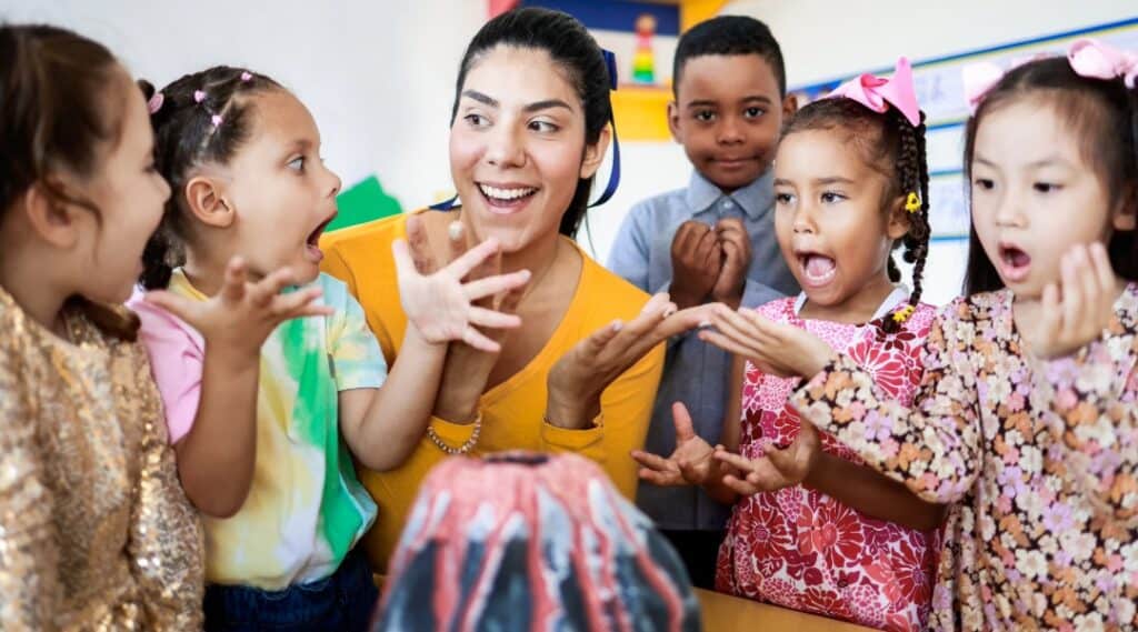 A teacher and a small group of students do a volcano experiment as part of the Montessori 5 great lessons