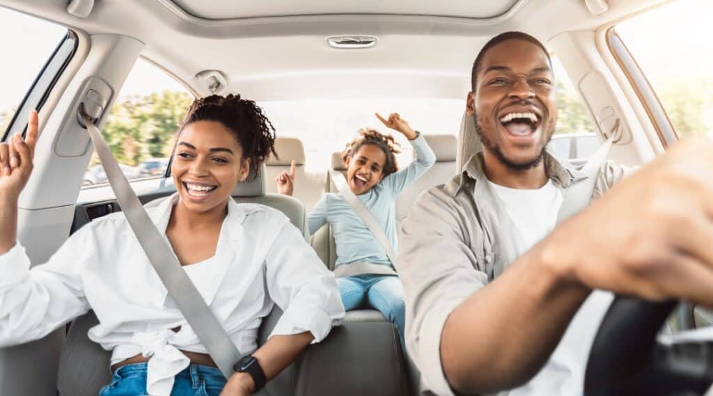 A family of a mom, dad, and daughter are in a car singing and having fun as they get into some planned games to play on road trips.