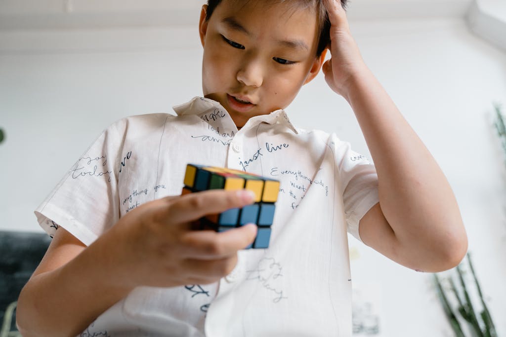 A child intensely focused on solving a Rubik's Cube, showcasing problem-solving skills.
