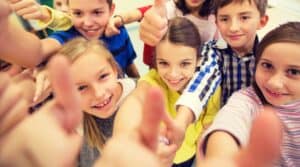 A group of elementary students giving a thumbs up because they love this word association game.