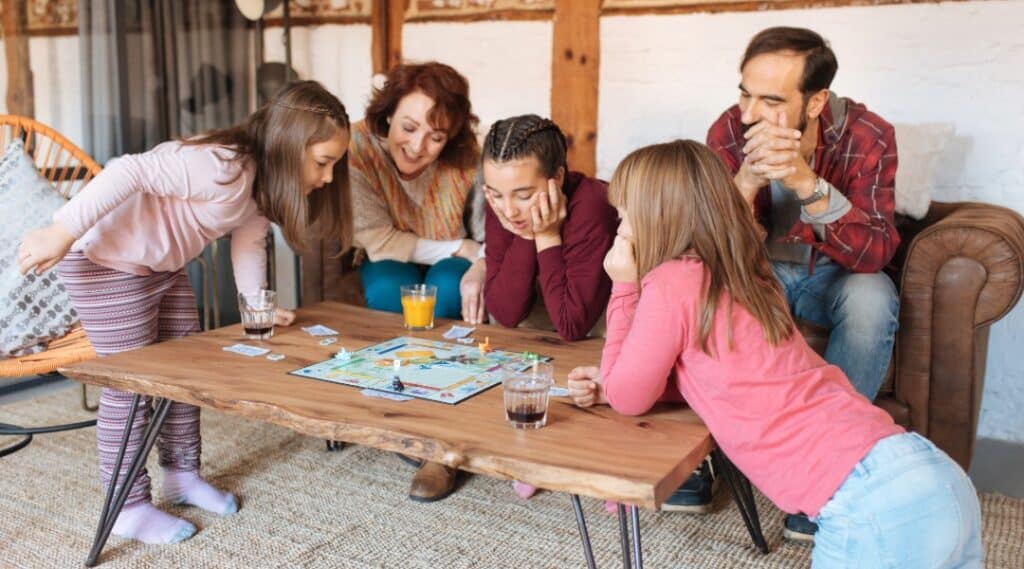 A family playing Monopoly. Of all the summer learning activities this is my fav!
