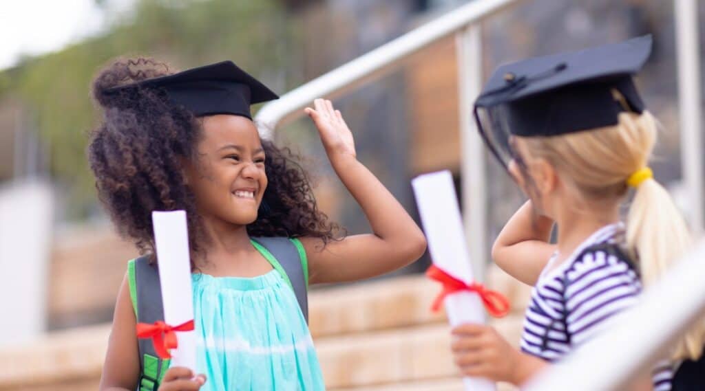 A picture of two happy elementary graduates. They are ready to join the most famous Montessori graduates as successful and motivated humans.