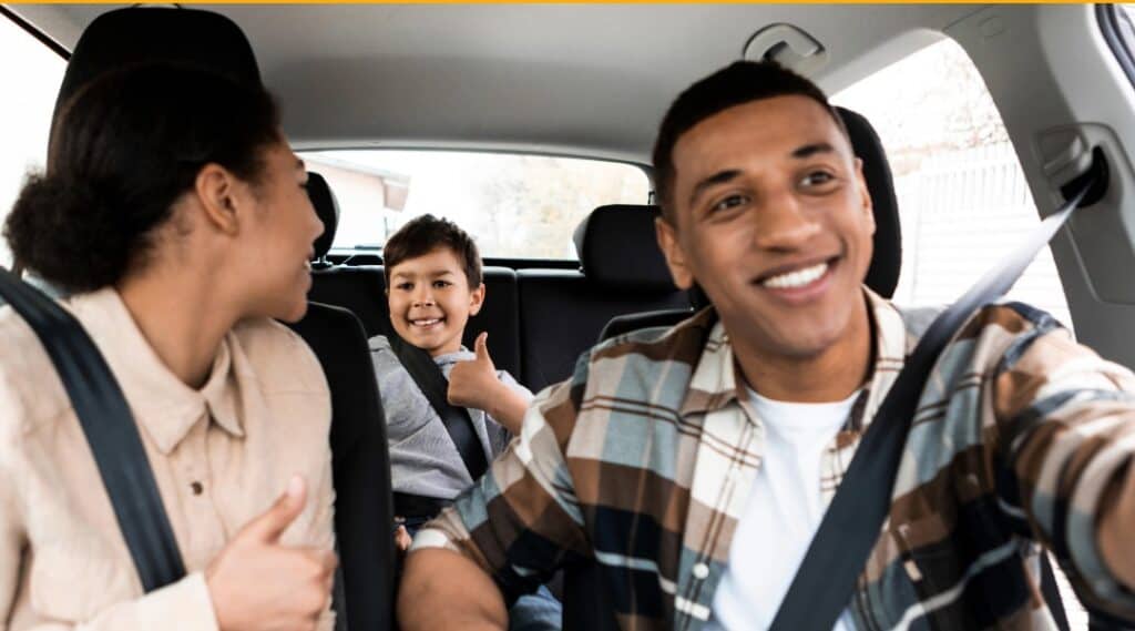 A family of three having fun with games to play on road trips.