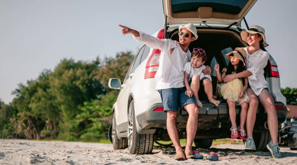 A family takes a break from a road trip to play some games at the beach.