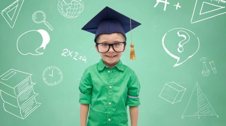 An image of an elementary aged boy wearing a green button up shirt and wearing a graduation cap.