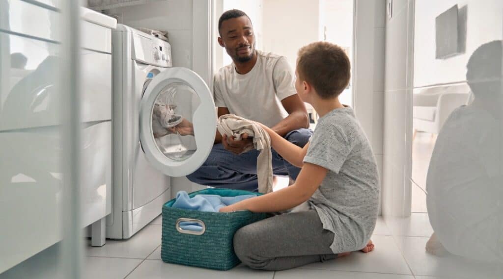Young child helping with household laundry.